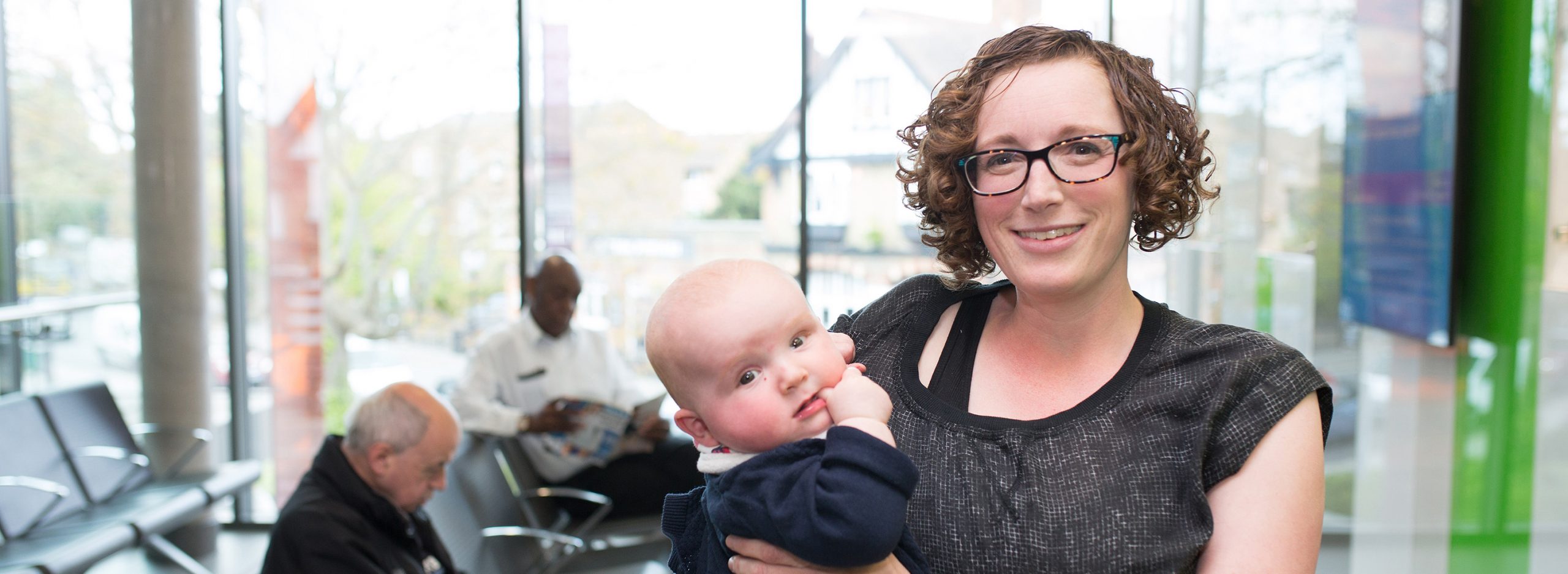 Woman holding baby in hospital waiting area